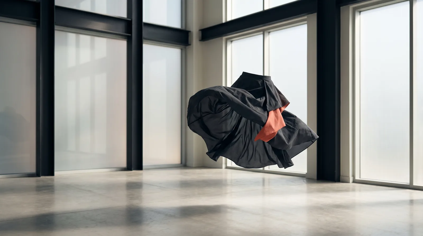 Technical fabric caught mid-motion, an abstract skirt silhouette frozen in the air