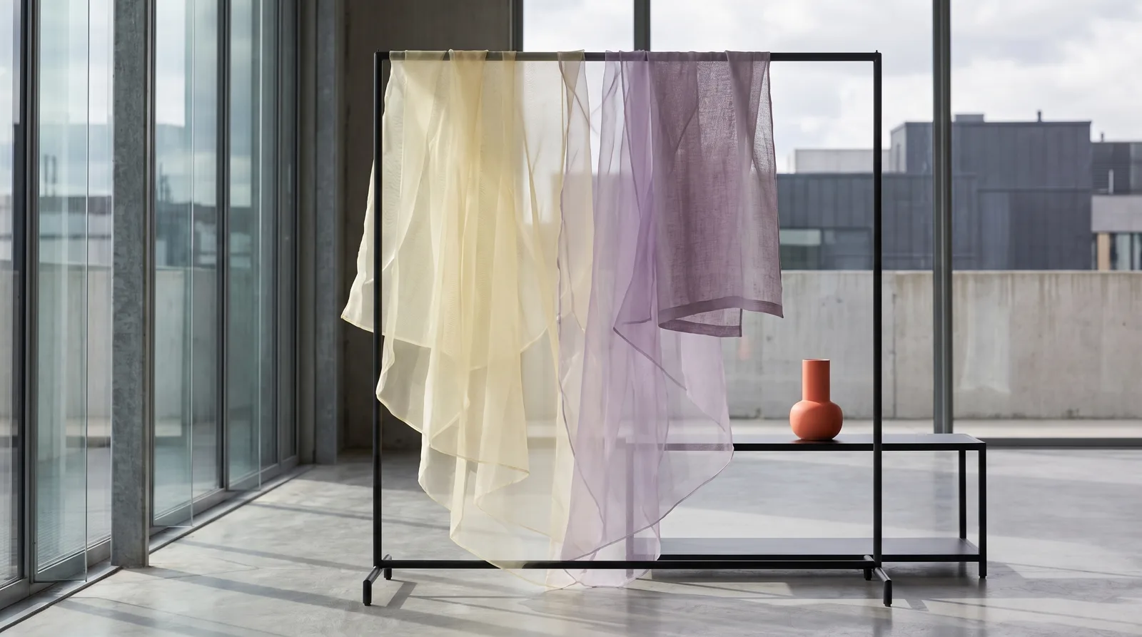 Organza and light linen on a steel rail, light filtering through the fabric